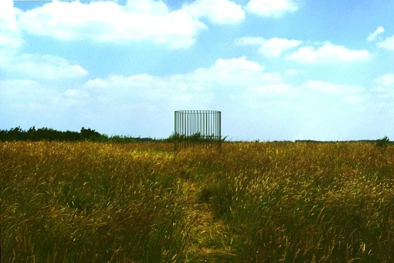 La cage est visible à contre-jour sur le ciel.